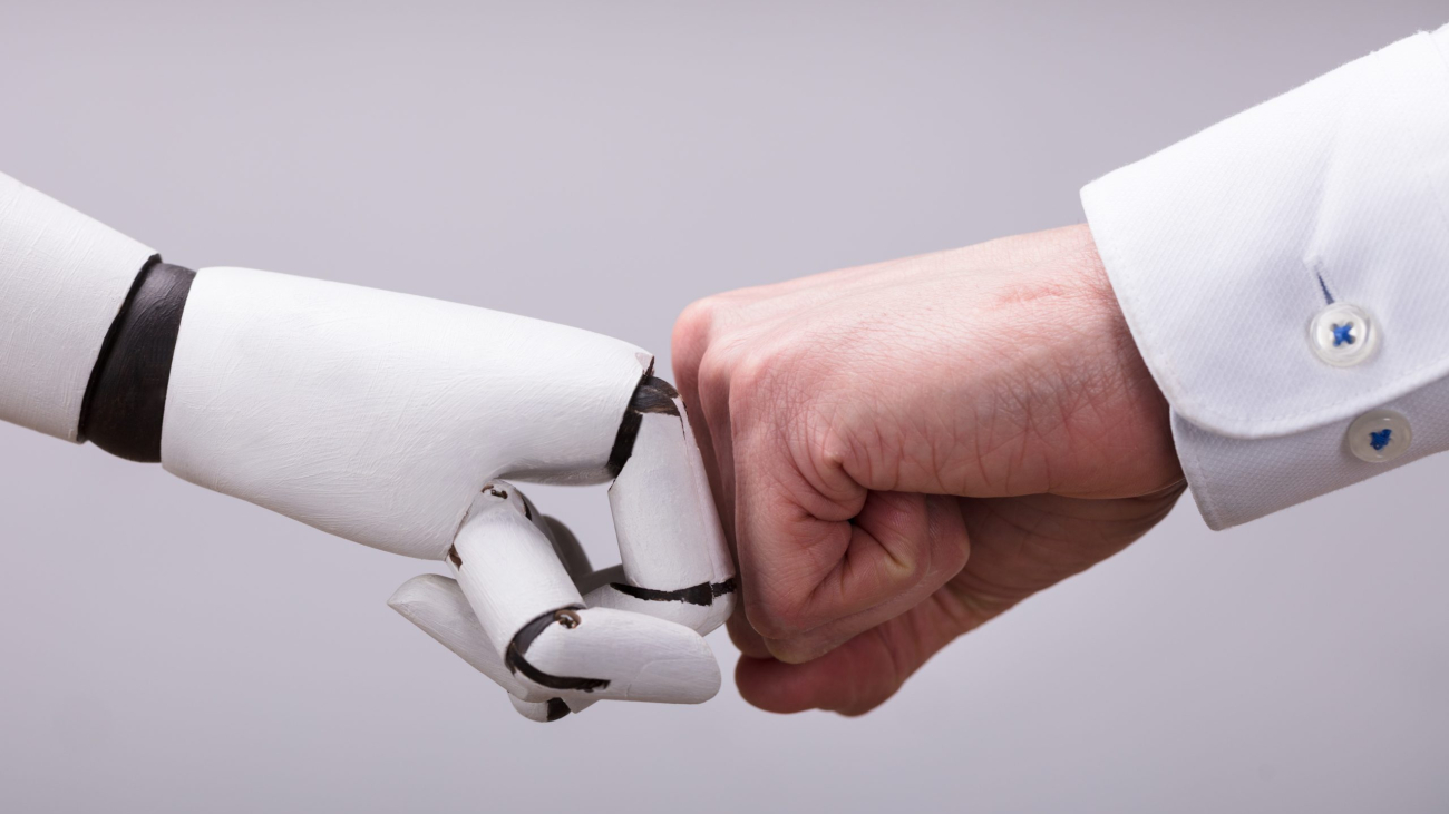 Robot And Human Hand Making Fist Bump On Grey Background